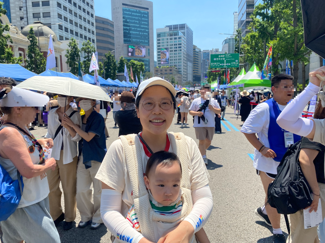 Baek So-young, 38, a clinical psychologist, poses with her baby during the 2026 Seoul Queer Parade in central Seoul on Saturday. The southern Seoul resident said it was her baby's first time crossing the Han River. (Lim Jae-seong/The Korea Herald)