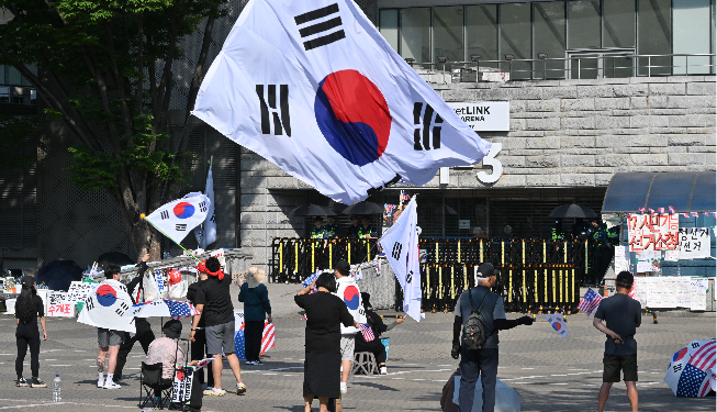 Protesters at Olympic Park in Seoul wave the national flag on Monday. (Im Se-jun/The Korea Herald)