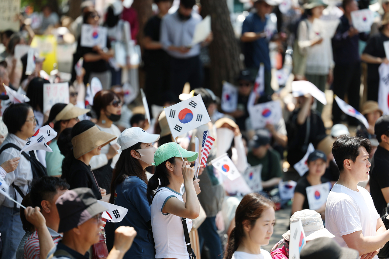 Participants wave South Korean flags during a protest calling for a revote of the June 3 local elections outside the Olympic Handball Gymnasium in Jamsil, southern Seoul, on June 9. (Yonhap)