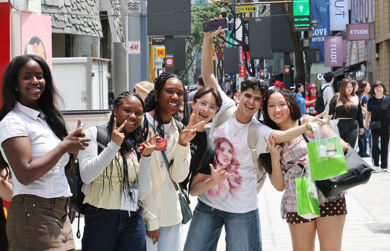 Tourists pose for a picture at Myeong-dong in central Seoul on June 9. (Yonhap)