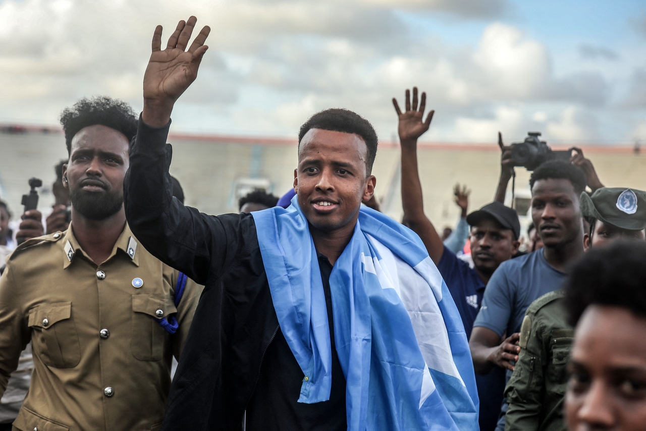 International referee Omar Abdulkadir Artan waves to supporters while draped in the Somali flag as he is welcomed ahead of a soccer match, after returning to Somalia, in Mogadishu, Wednesday.    (AFP-Yonhap)