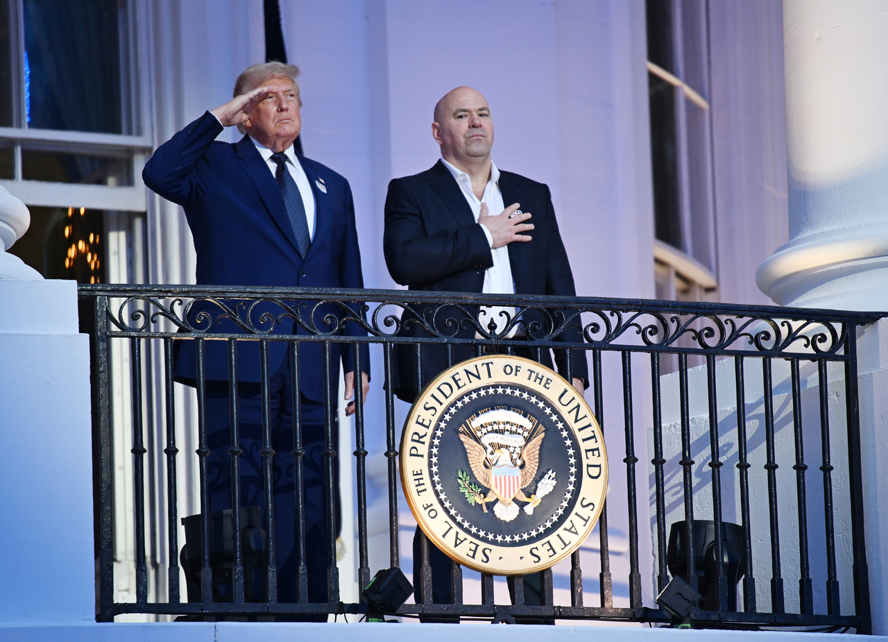 US President Donald Trump (left) and United Fighting Championship CEO Dana White stand on a balcony at the White House in Washington on Sunday. (UPI-Yonhap)