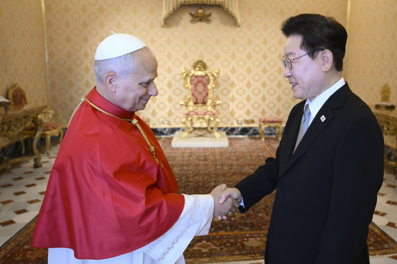 President Lee Jae Myung shakes hands with Pope Leo XIV ahead of their private meeting at the Apostolic Palace in Vatican City on Sunday. (Vatican Media-Yonhap)