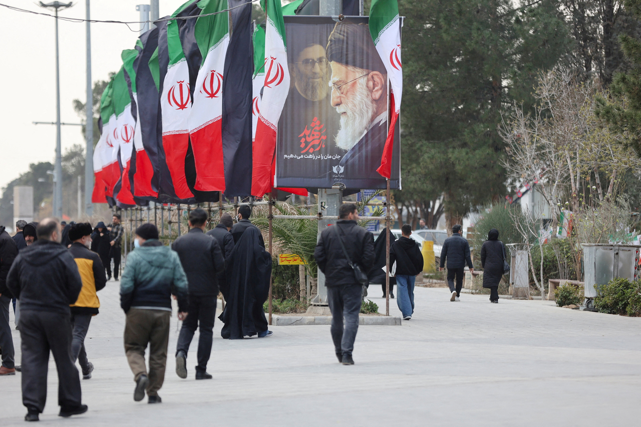 People walk along a street with Iranian flags and a poster with images of Iran's late Supreme Leader Ayatollah Ali Khamenei, amid the US-Israeli conflict with Iran, in Tehran, Iran, in March. (Reuters-Yonhap)