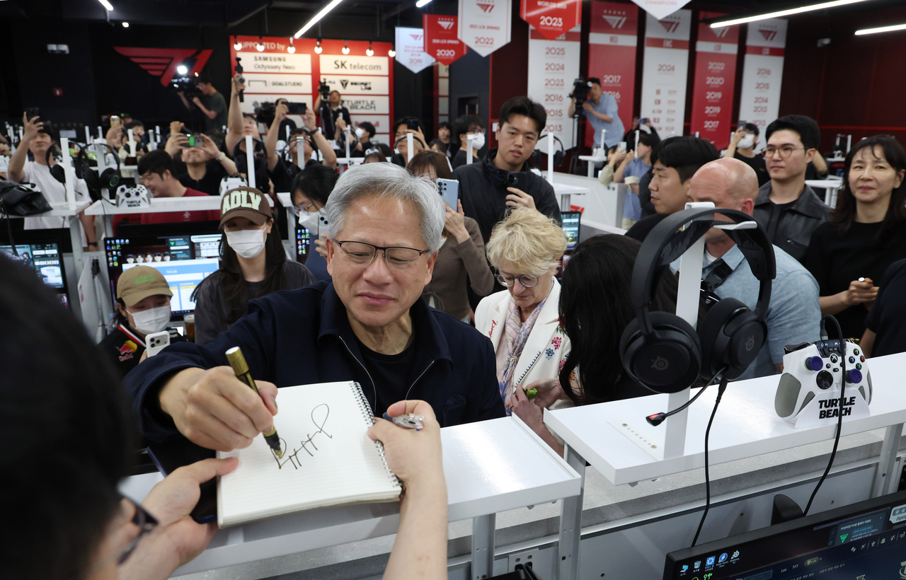 Nvidia CEO Jensen Huang meets gamers and signs autographs at T1 Base Camp in Hongdae on Friday, drawing crowds during the first stop of his Korea visit. (Yoon Chang-bin/The Korea Herald)
