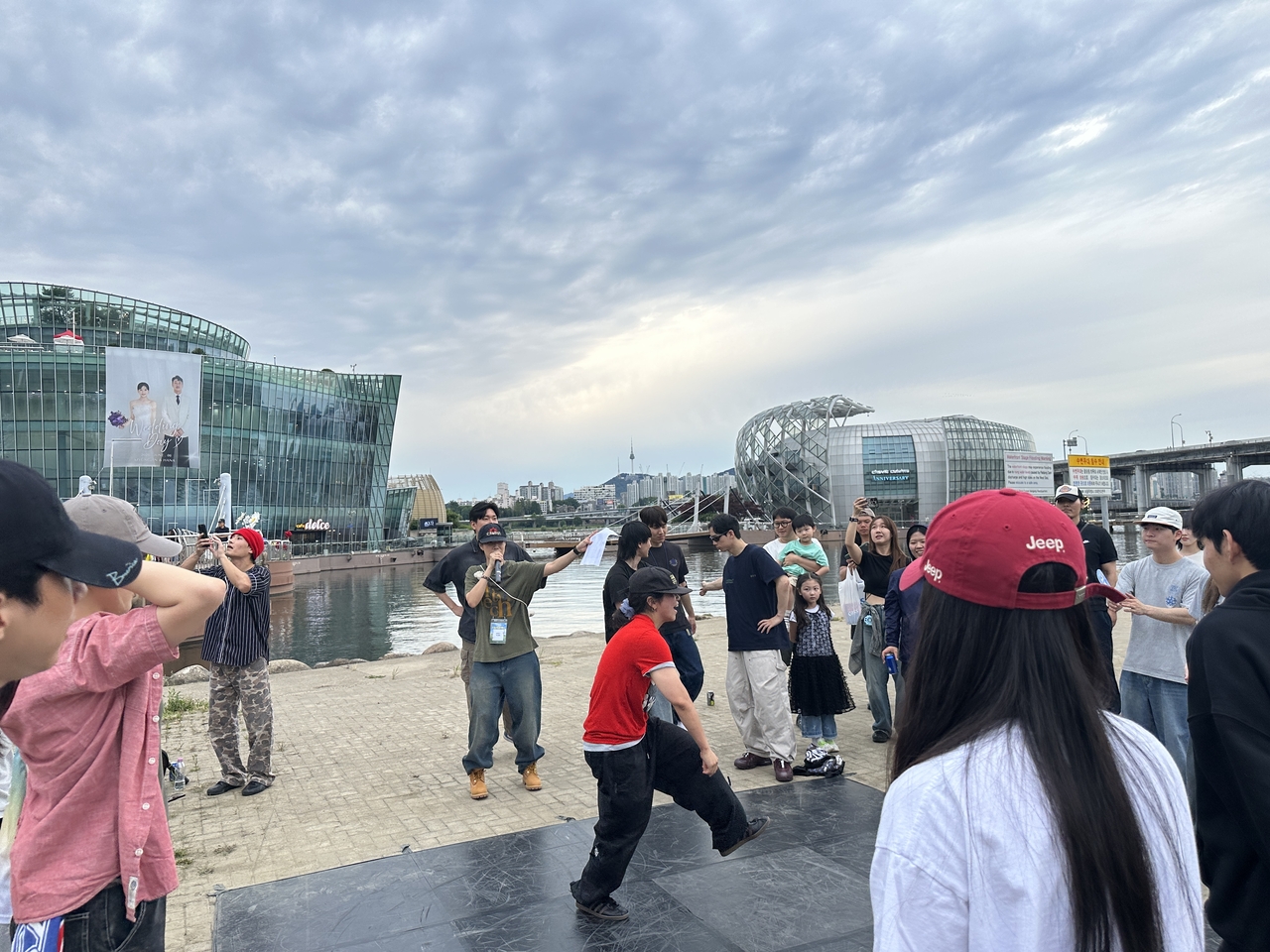 A young dancer freestyles during the open session at Hangang Jam. The person in the center holding a microphone is Kwon Yu-kyung, who served as the event’s MC for the first time. (Tammy Park/The Korea Herald)