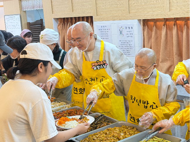Ven. Seonjae (right) serves temple food to university students at Yeonhwasa in Seoul on Tuesday. (Hong Yoo/The Korea Herald)