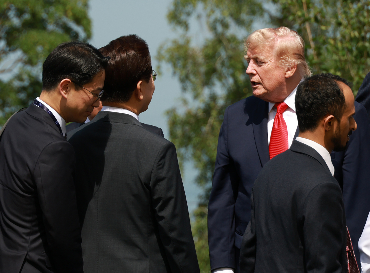 President Lee Jae Myung speaks with US President Donald Trump after a commemorative photo session at the host country’s welcome reception for invited nations held at the Group of Seven summit venue in Évian-les-Bains, France on June 16 (local time).  (Yonhap)