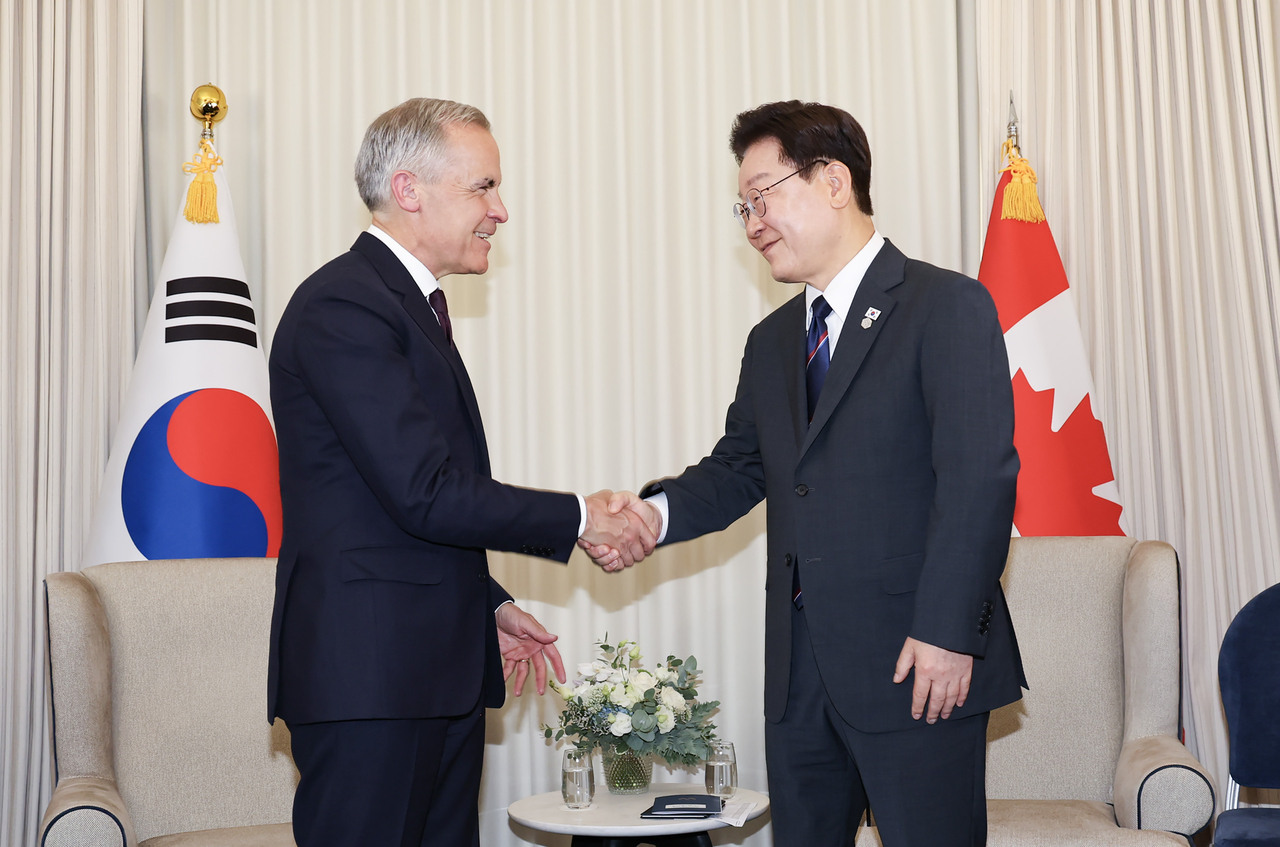 President Lee Jae Myung and Canadian Prime Minister Mark Carney greet each other ahead of a bilateral meeting on June 16 (local time) at the G7 summit venue in Évian-les-Bains, France. (Yonhap)