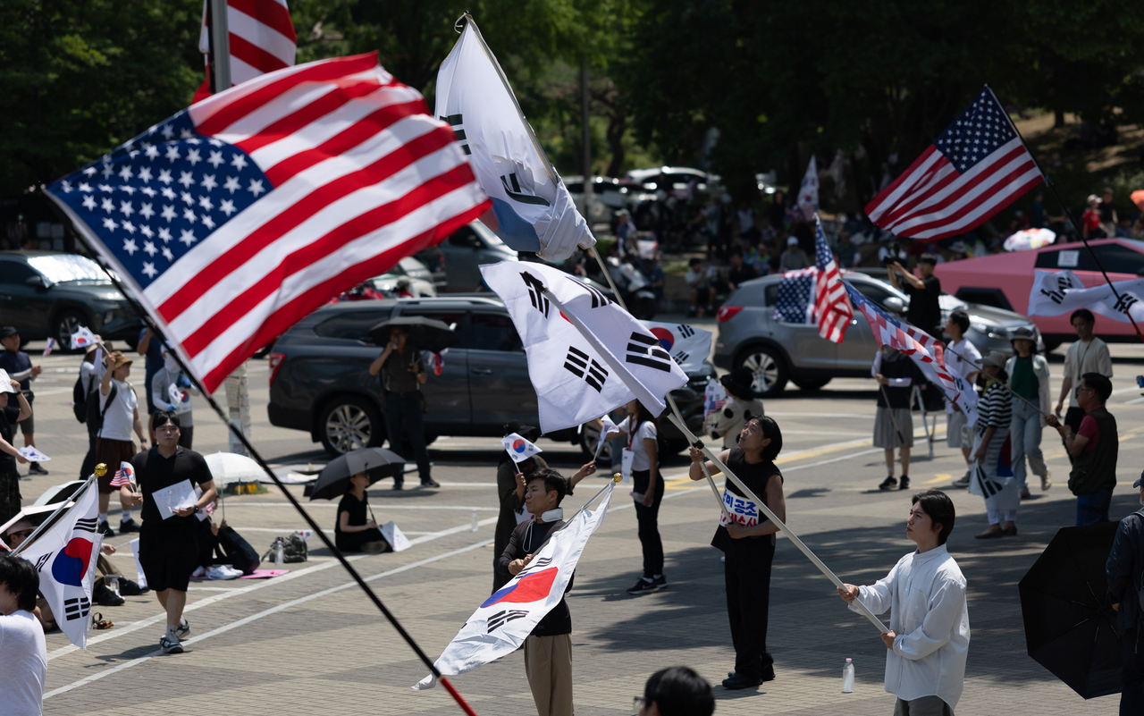 People wave flags at a rally calling for an election rerun at Olympic Park in Songpa-gu, Seoul, Wednesday. (Yoon Chang-bin/The Korea Herald)