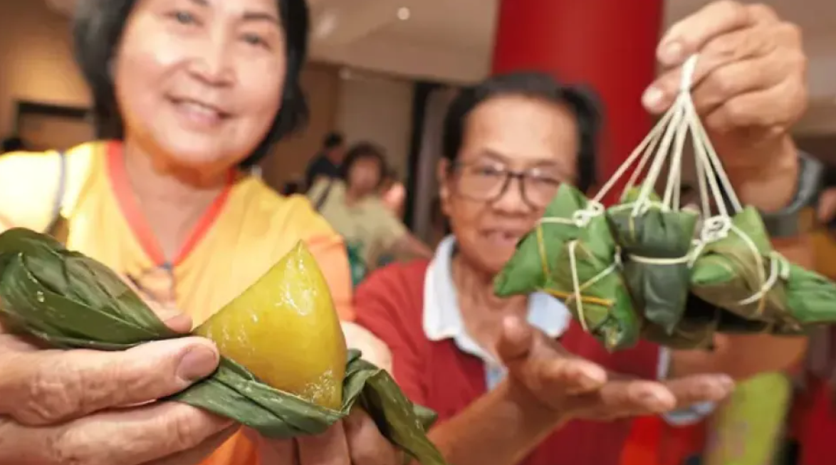 Traders presenting the kee chang dumplings, which are sold to visitors at the Dragon Boat Festival in Penang Chinese Town Hall in Penang, Malaysia.    (The Star)
