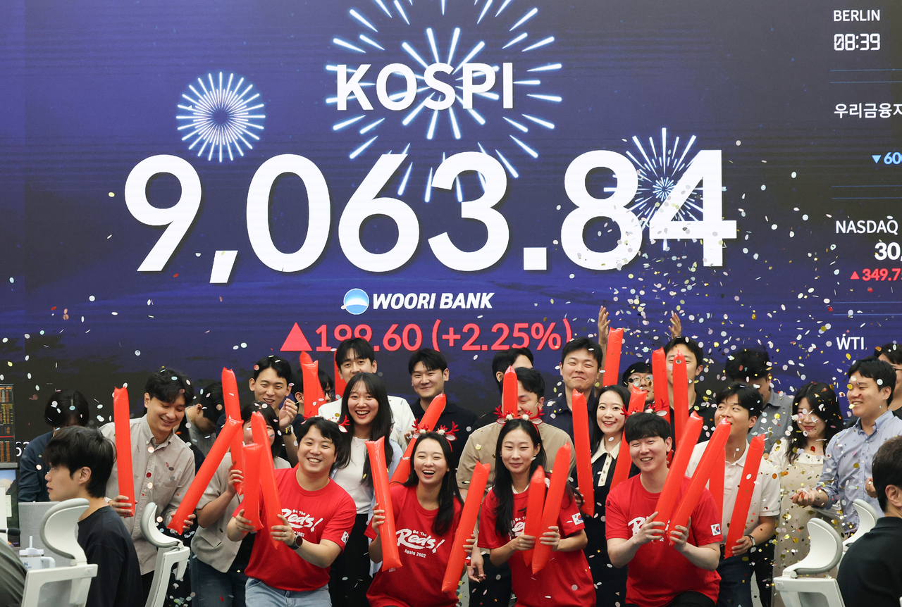 A display at Woori Bank in Seoul on Thursday shows the Kospi powering over the 9,000 mark for the first time as of trading's close. The milestone comes a month after it reached the 8,000-point level on May 26. (Yonhap)