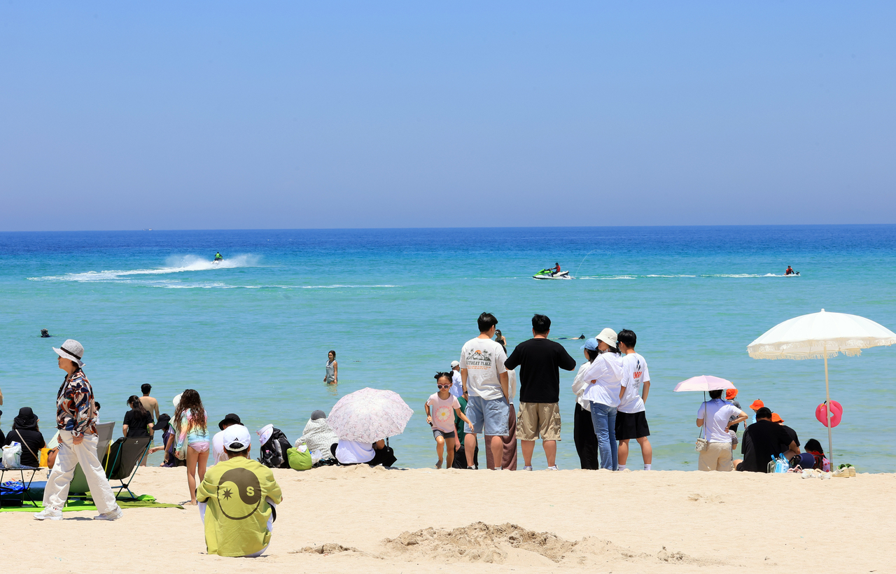 Beachgoers enjoy the early summer atmosphere at Hamdeok Beach in Jocheon-eup, Jeju, on May 31. (Yonhap)