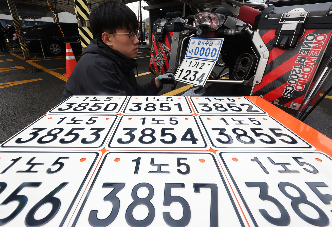 An official displays the new nationwide motorcycle license plate at the Suwon Urban Development Corporation’s license plate production center in Gwonseon-gu, Suwon, on March 18, ahead of its introduction on the 20th. The photo is unrelated to the article. (Yonhap)