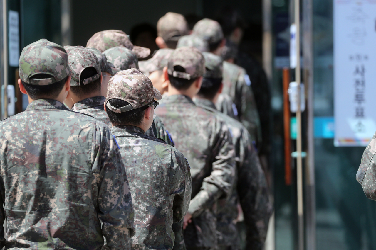 Army soldiers stand in line to cast their vote at a polling station in Gangwon Province on May 29. This photo is not related to the story. (Yonhap)