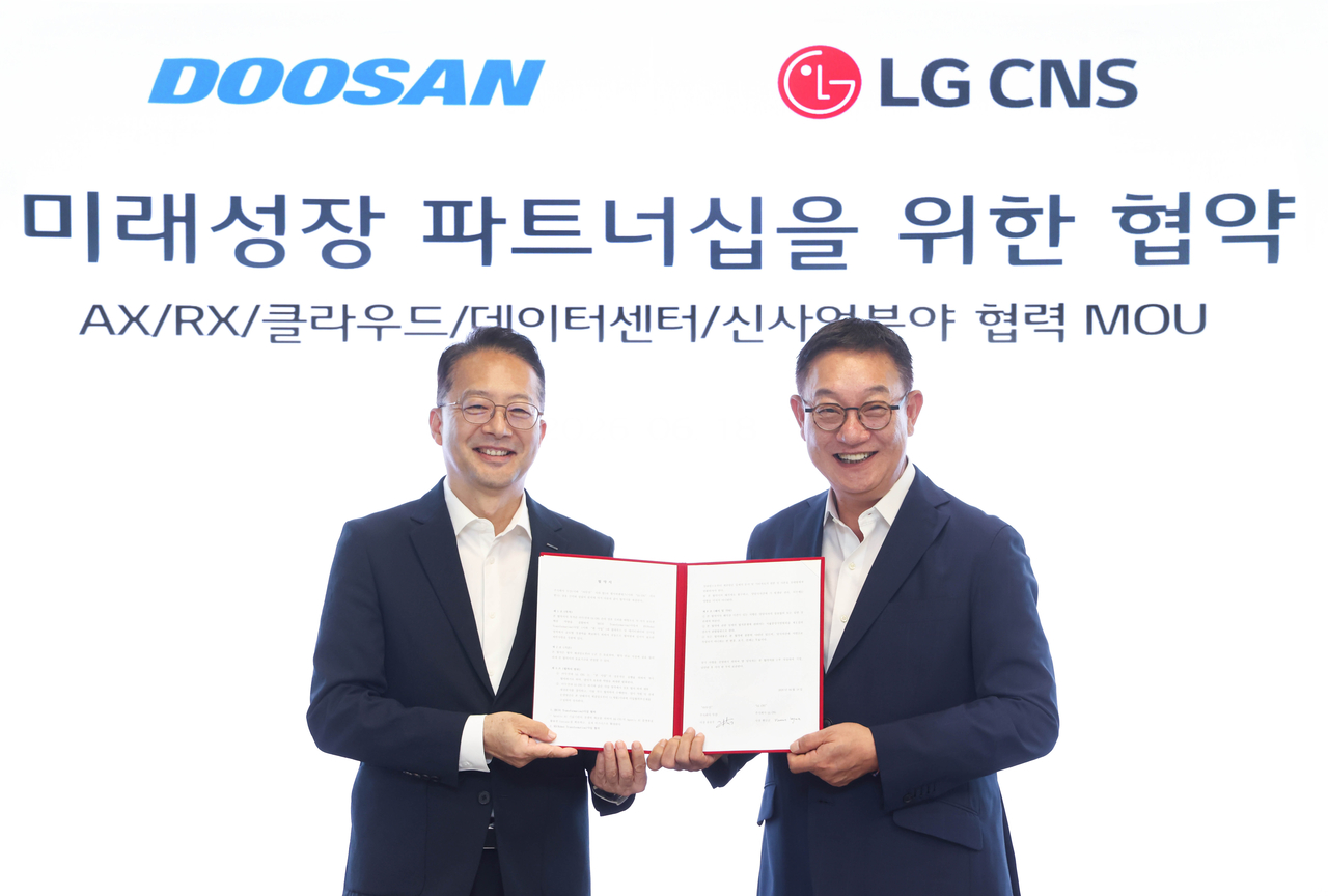 Yoo Seung-woo (left), president of Doosan Corp., and Hyun Shin-gyoon, president of LG CNS, pose for a photo after signing a memorandum of understanding at LG Science Park in western Seoul, Thursday. (Doosan Corp.)