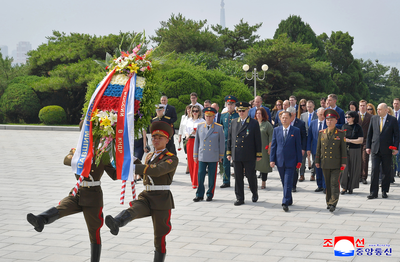 Officials with the Russian embassy in North Korea pay tribute to the monument for Russian soldiers in Pyongyang on June 11. (Yonhap)