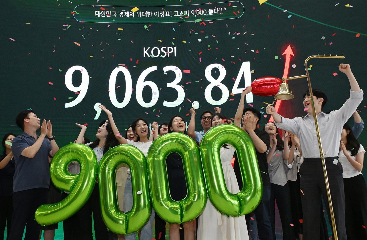 Traders celebrate a new KOSPI milestone at a dealing room in Hana Bank in central Seoul on Thursday. (Yonhap)