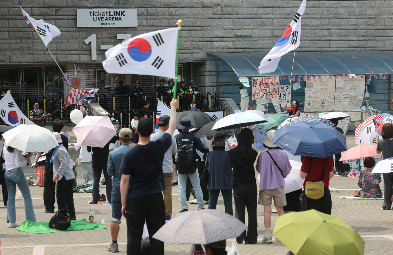Protesters chant slogans outside the Olympic Park Handball Gymnasium in southern Seoul on June 18, 2026, in protest of ballot shortages during the June 3 local elections. (Yonhap)