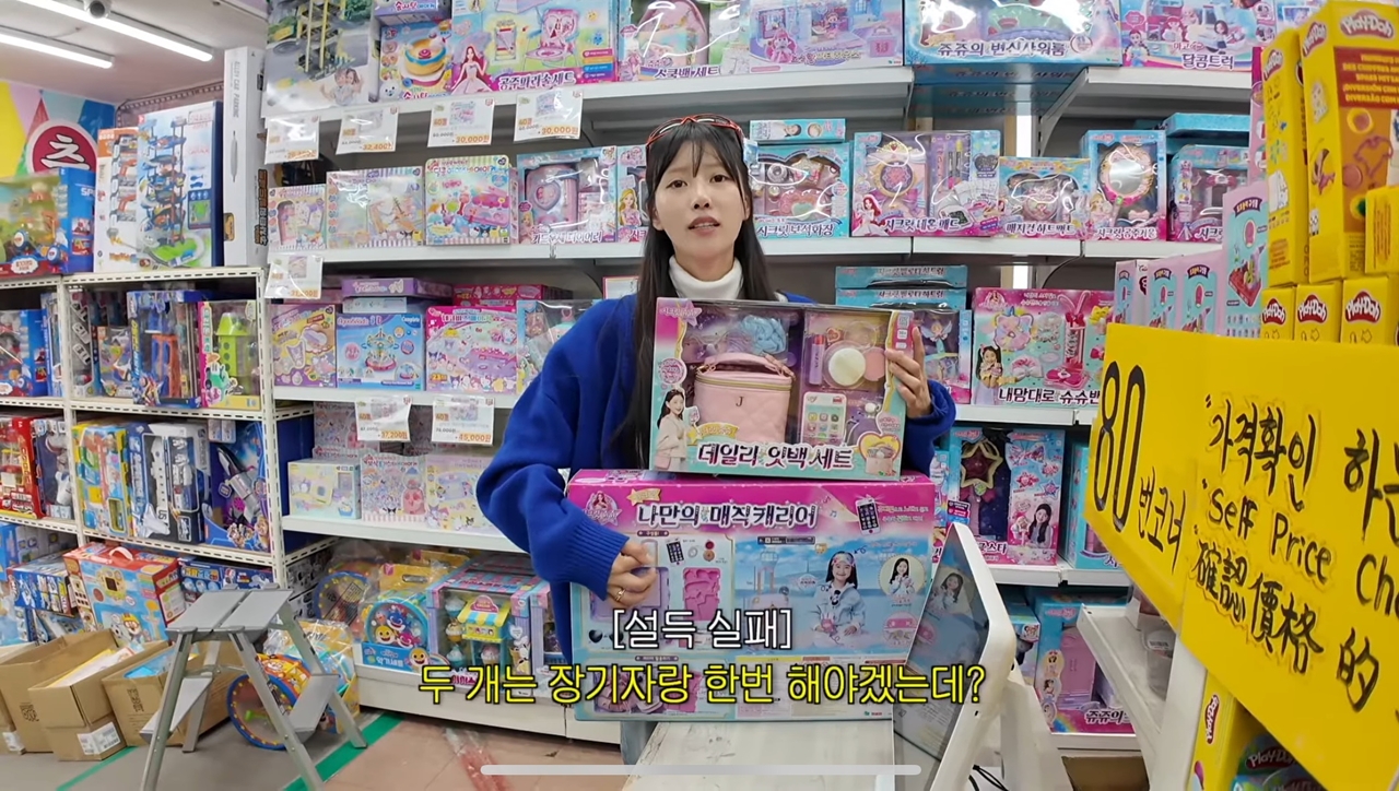 A captured image shows singer and television personality Mijoo browsing toys along Dongmyo’s toy street, an area known for its assortment of vintage collectibles and retro items. (YouTube)
