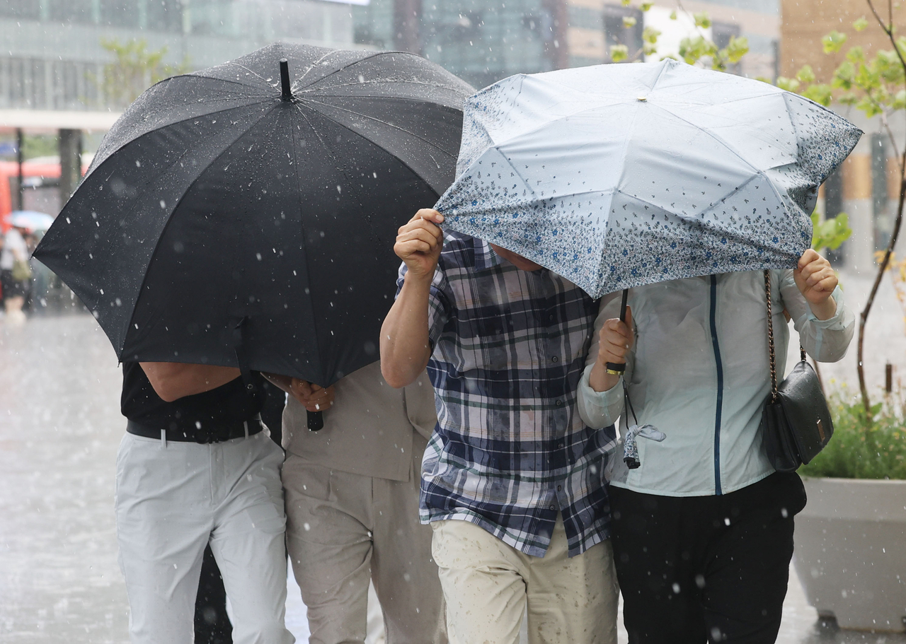 Pedestrians walk in rain at Gwanghwamun Square in Jongno, central Seoul, June 13. (Yonhap)
