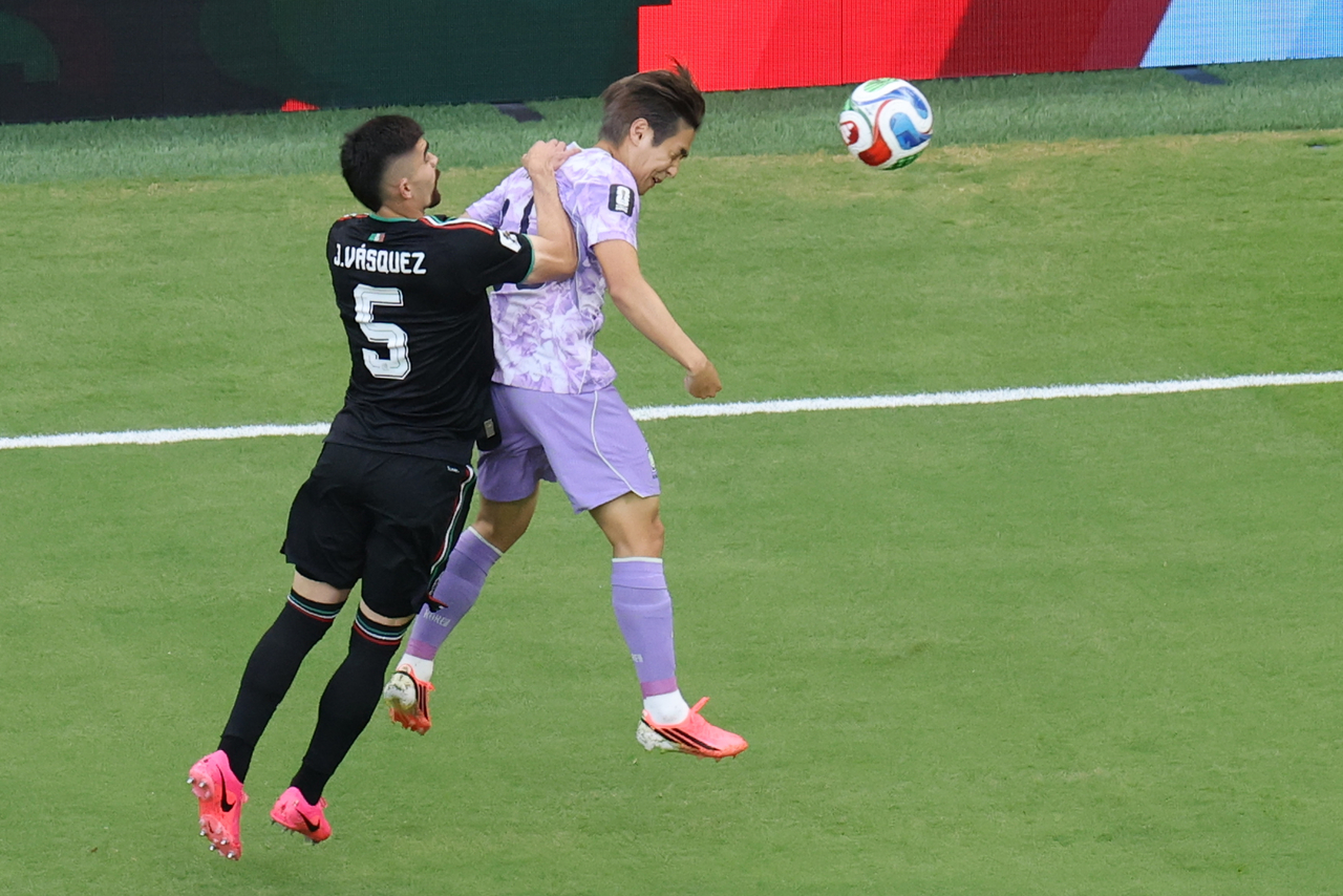 South Korea's Lee Kang-in (right) jumps for the ball during a Group A World Cup match against Mexico, in Zapopan, Mexico, Friday. (Yonhap)