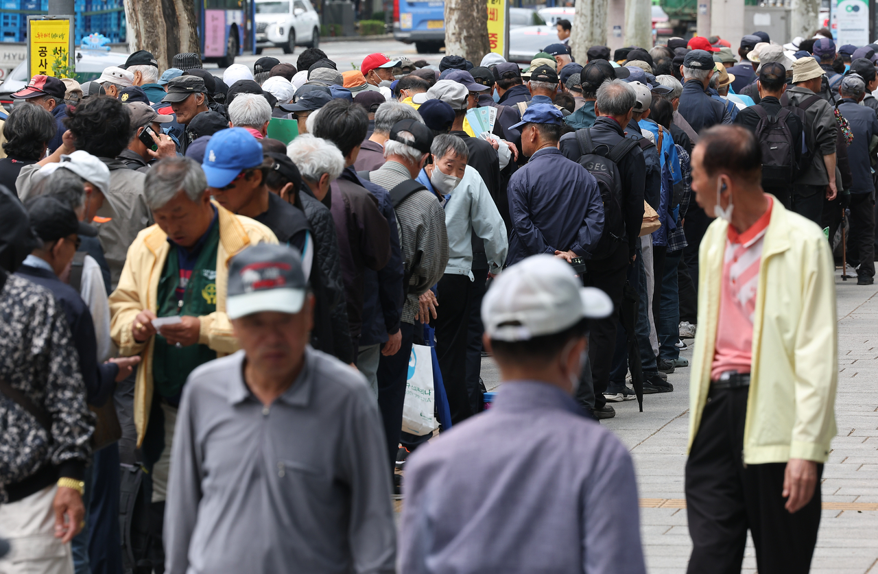 Senior citizens wait in line for a free meal at Topgol Park in Jongno-gu, Seoul, on May 7. (Yonhap)