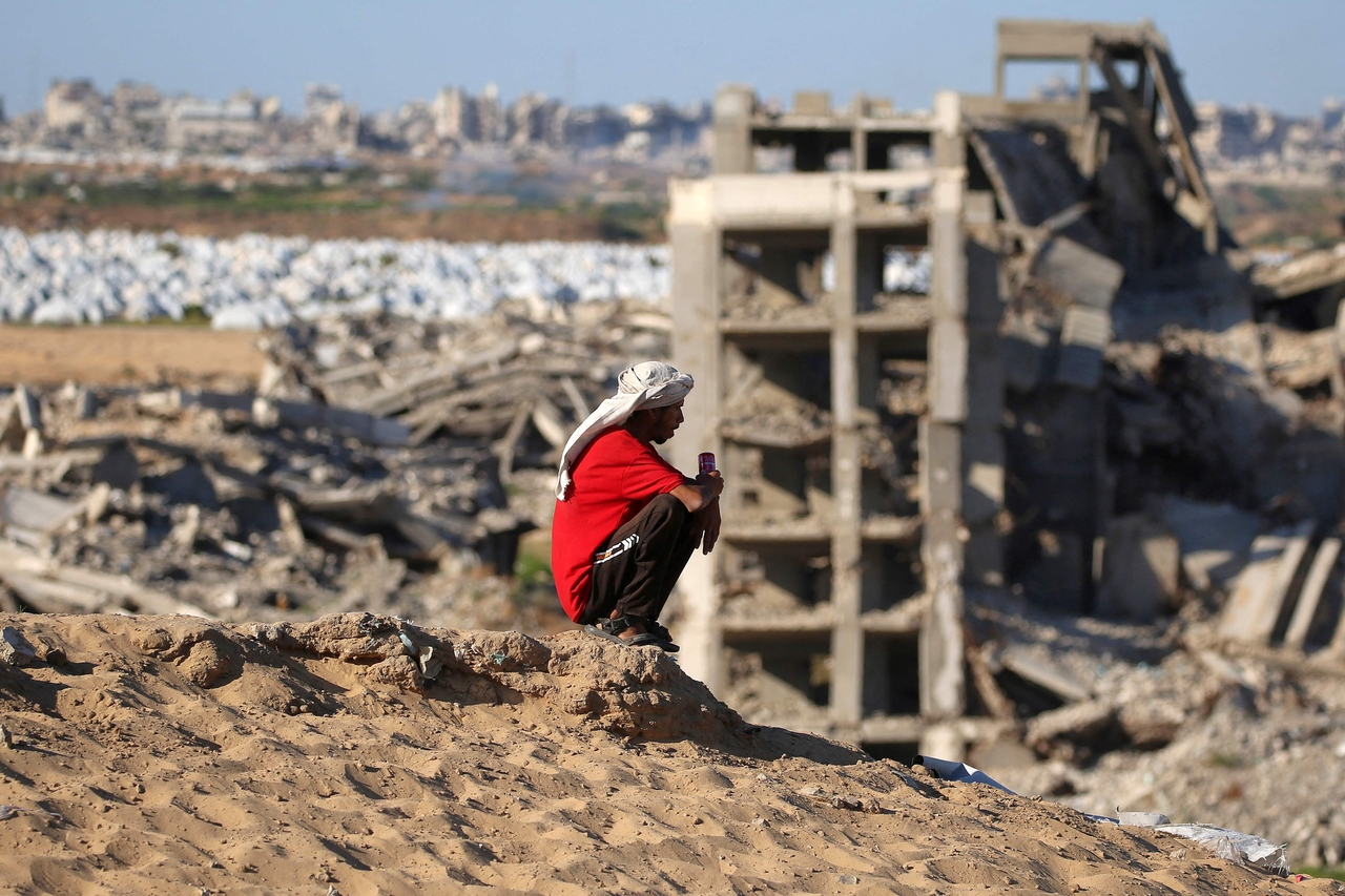 A man sits atop a hill near destroyed and heavily-damaged buildings at the Nuseirat camp for Palestinian refugees in the central Gaza Strip on Friday. (AFP-Yonhap)