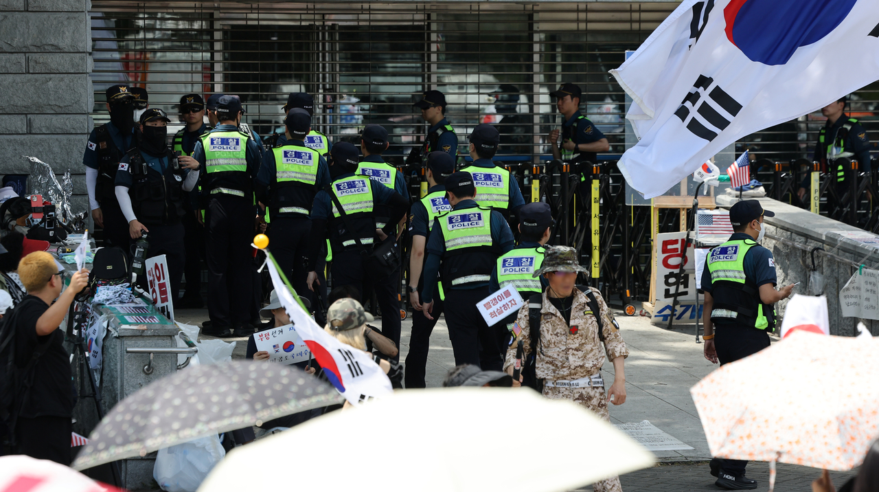 Police officers rotate shifts in front of the entrance to the Olympic Park Handball Gymnasium in Songpa-gu, Seoul, on Sunday, where a blockade protest over a ballot shortage during the June 3 local elections continues. [Yonhap]