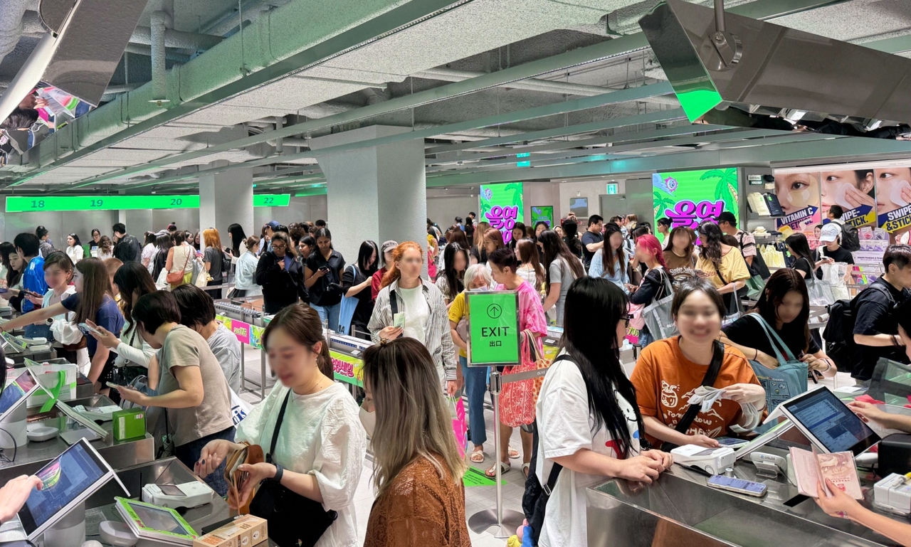Foreign shoppers browse Olive Young's Central Myeongdong Town store during the June sale season. (CJ Olive Young)