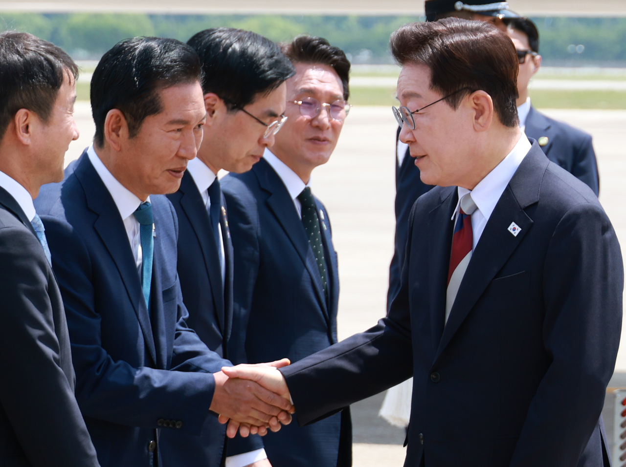 President Lee Jae Myung (right) shakes hands with Rep. Jung Chung-rae, leader of the ruling Democratic Party, after arriving at Seoul Airport in Seongnam, south of Seoul, on June 18, 2026, winding up a 10-day trip to Europe that included his attendance at the Group of Seven summit in Evian-les-Bains, France. (Yonhap)