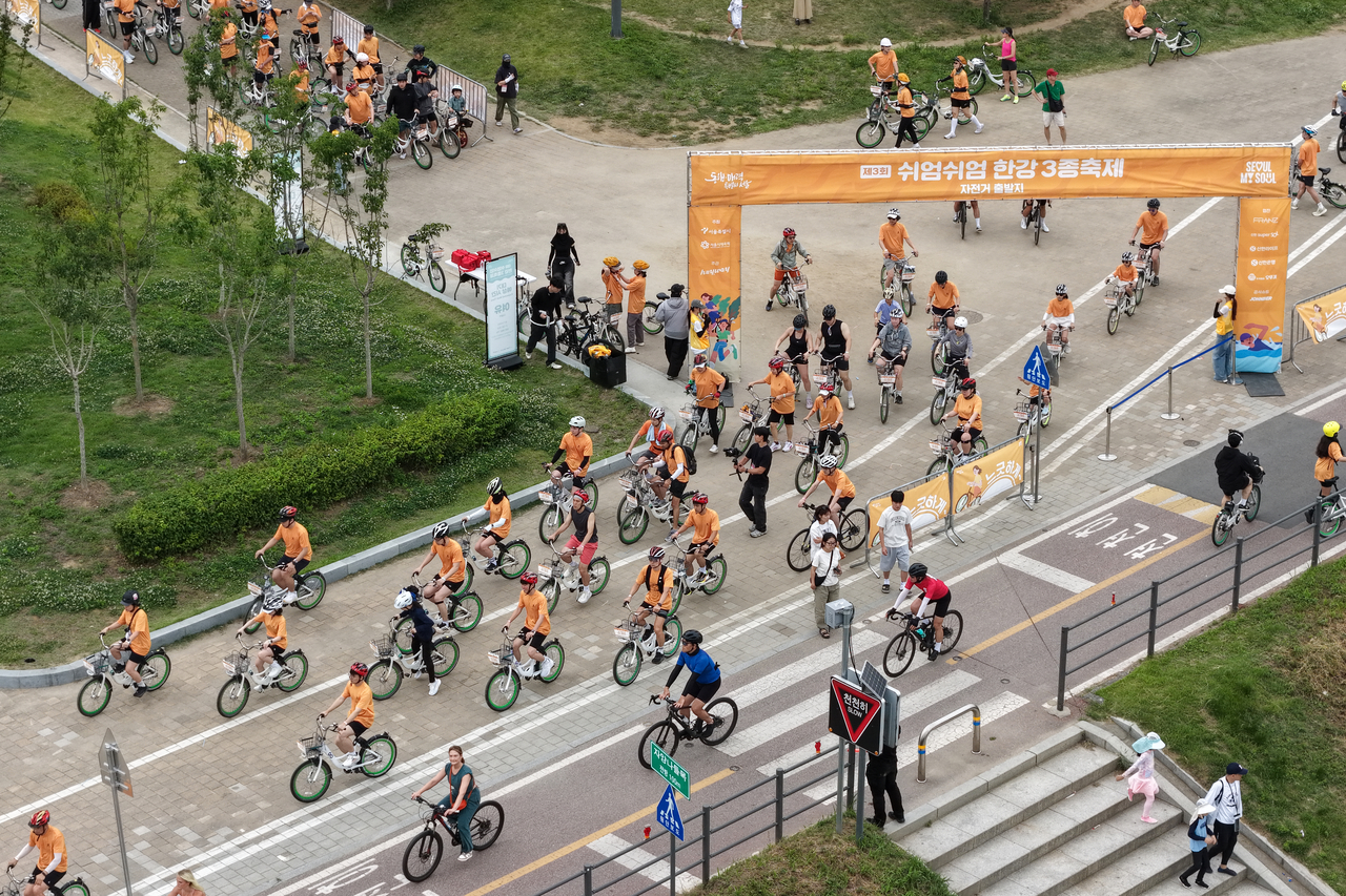 Athletes participate in the cycling portion of an untimed triathlon, at Ttukseom Hangang Park in Seoul on June 7. (Yonhap)