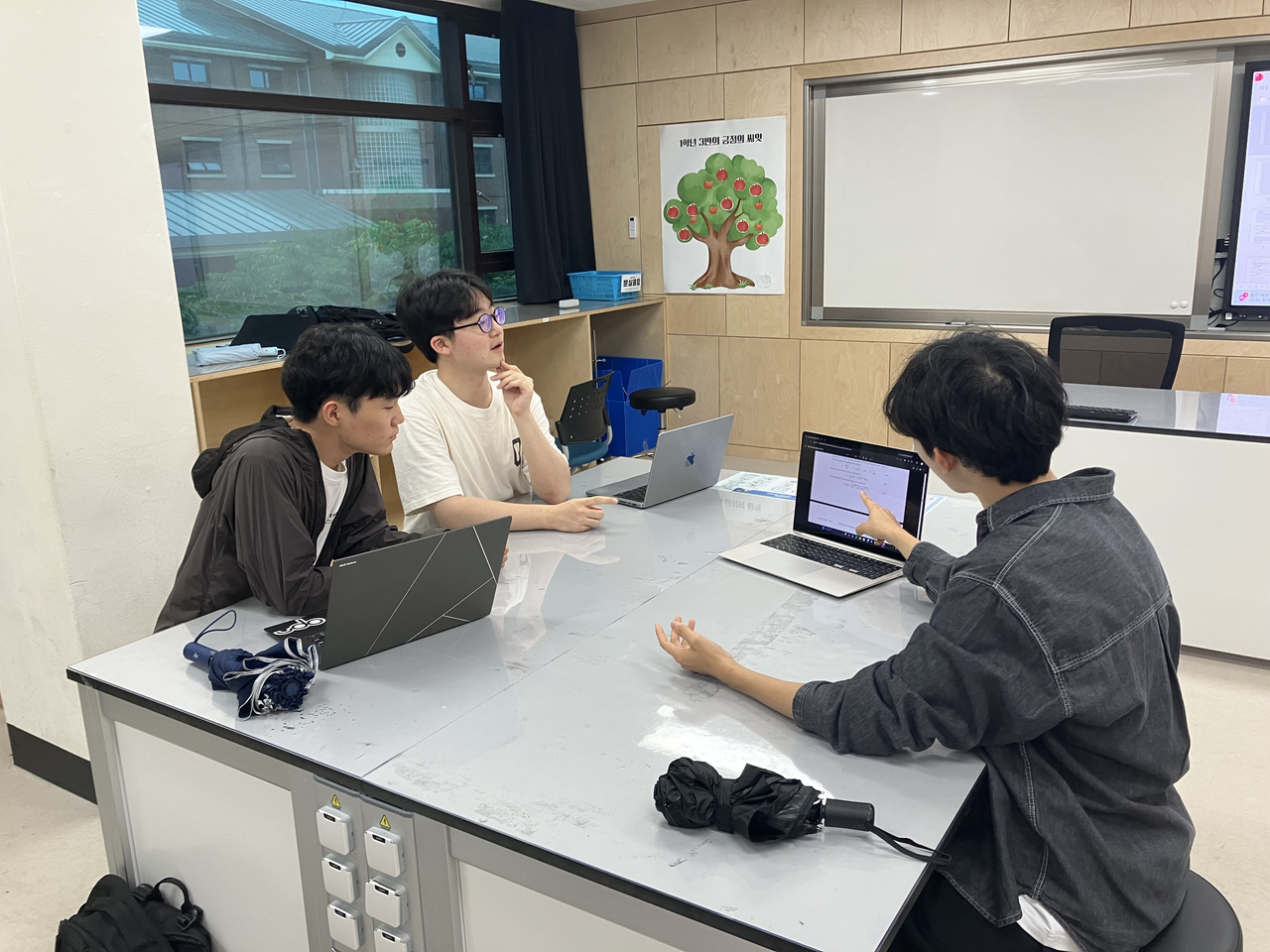 Seoul Science High School students Bae I-jin (first from left), Jang Geun-young (second from left) and Ahn Geon-woo discuss their research. (Seoul Science High School)