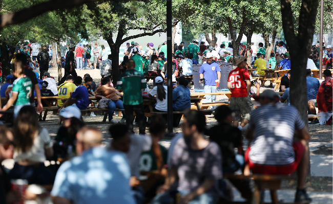 Football fans rest in the shade at a FIFA Fan Festival in Monterrey, Mexico, Monday, amid a scorching heat wave, with strong sunlight and high humidity pushing real-feel temperatures close to 40 degrees Celsius. (Yonhap)