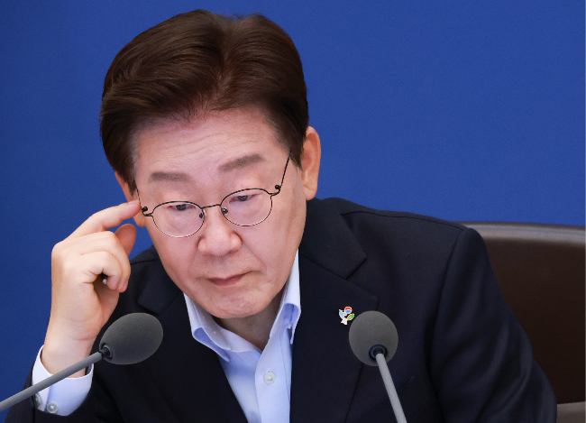 President Lee Jae Myung reviews documents during a Cabinet meeting and emergency economic review session at Cheong Wa Dae in Seoul on Tuesday. (Yonhap)