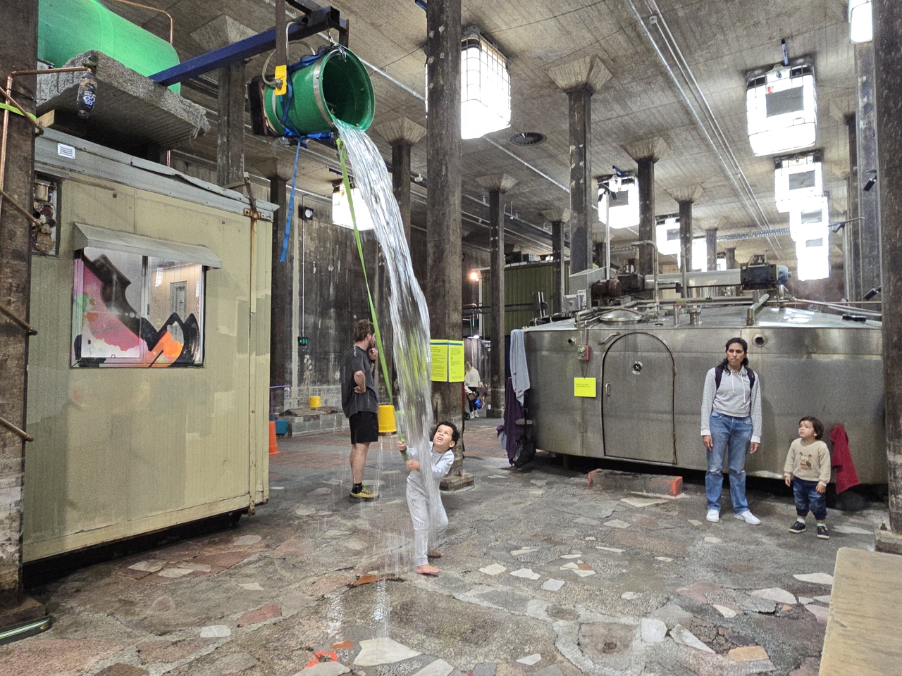 A water-bucket ride built from recycled materials — a junk-recycling lifestyle art piece in the style of a theme park attraction