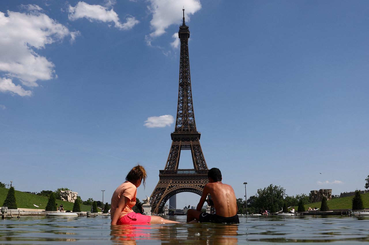 People cool off in the Trocadero Fountain next to the Eiffel Tower in Paris on Monday. (Reuters-Yonhap)