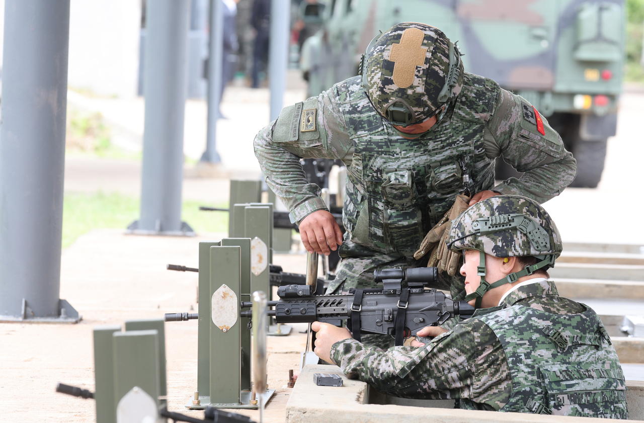 President Lee Jae Myung fires a K2C1 rifle during a visit to a Marine Corps unit on Yeonpyeongdo near the Northern Limit Line, the de facto sea border with North Korea in the Yellow Sea, on Thursday, the week of the 76th anniversary of the outbreak of the 1950-53 Korean War. (Pool photo via Yonhap)