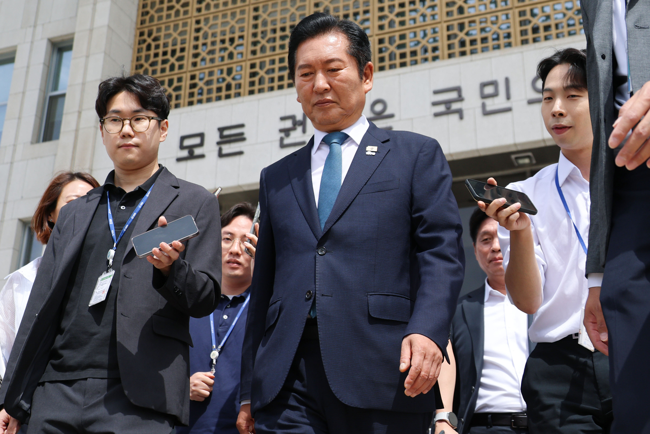 Rep. Jung Chung-rae (center) leaves after announcing his intention to resign as leader of the ruling Democratic Party of Korea during the party's Supreme Council meeting at the National Assembly in Seoul on Wednesday. (Yonhap)