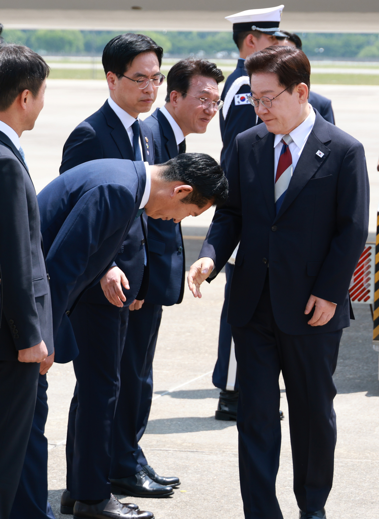 Rep. Jung Chung-rae (second from left) bows to President Lee Jae Myung (right), as the president arrived at Seoul Air Base in Seongnam, Gyeonggi Province, after his trip to Europe on June 18. (Yonhap)