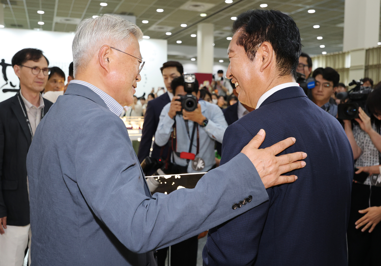 Rep. Jung Chung-rae (right) and former President Moon Jae-in meet at the Seoul International Book Fair at Coex in Gangnam-gu, Seoul, Wednesday. (Pool photo via Yonhap)