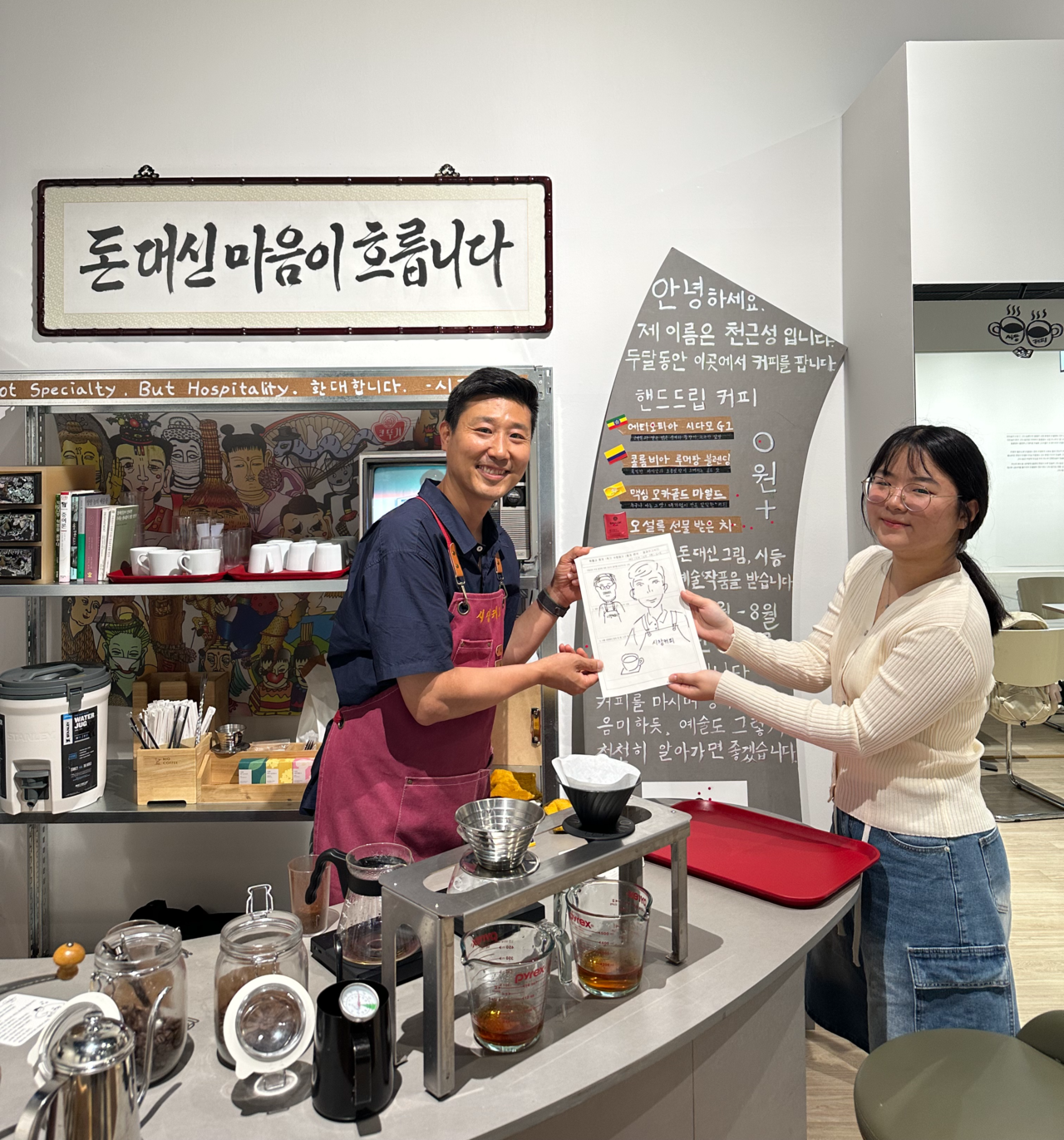 Chun Geun-sung receives a drawing in exchange for coffee during a public art program held in collaboration with the Suwon Museum of Art near Suwon Station on Feb. 27. (Chun Geun-sung)