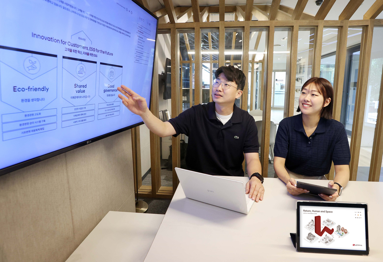 LX Hausys employees review the company's sustainability report published Thursday. [LX Hausys]