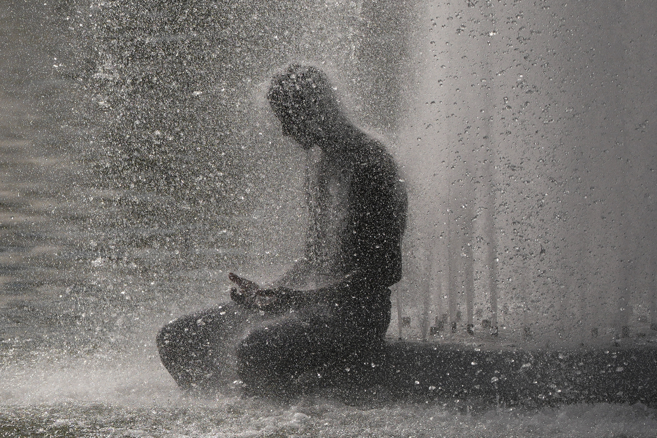 A person cools off at a fountain near the Eiffel Tower during a heat wave in Paris, Wednesday. (AP-Yonhap)