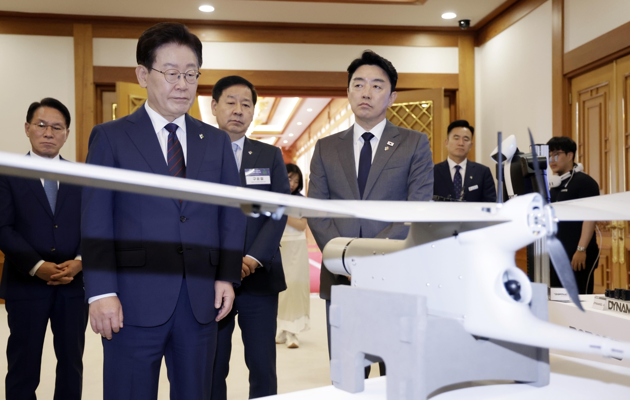 President Lee Jae Myung looks at a reconnaissance unmanned aerial vehicle on display ahead of a strategy meeting on fostering future security innovation companies at Cheong Wa Dae in Seoul on Friday. (Pool Photo via Yonhap)