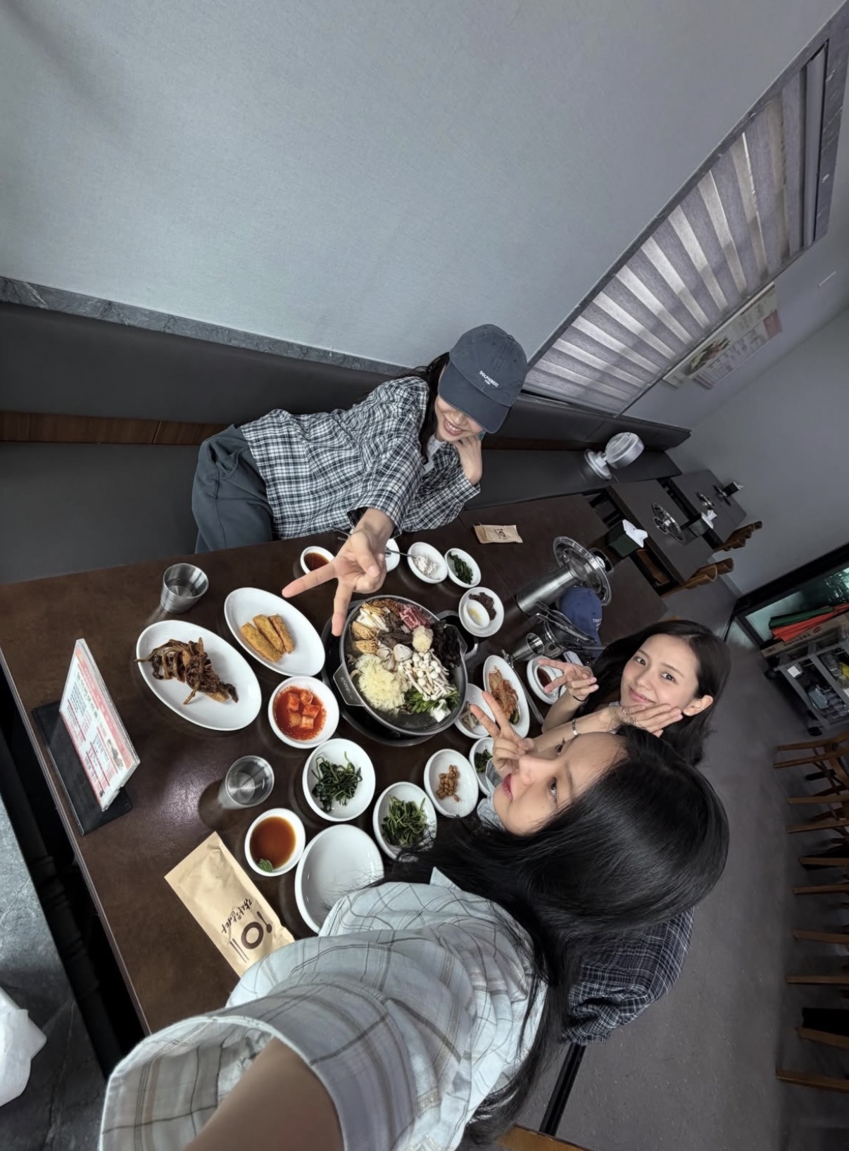 Hyeri's post includes a shot of the three friends posing at the table at Sandeurae restaurant. (Instagram)