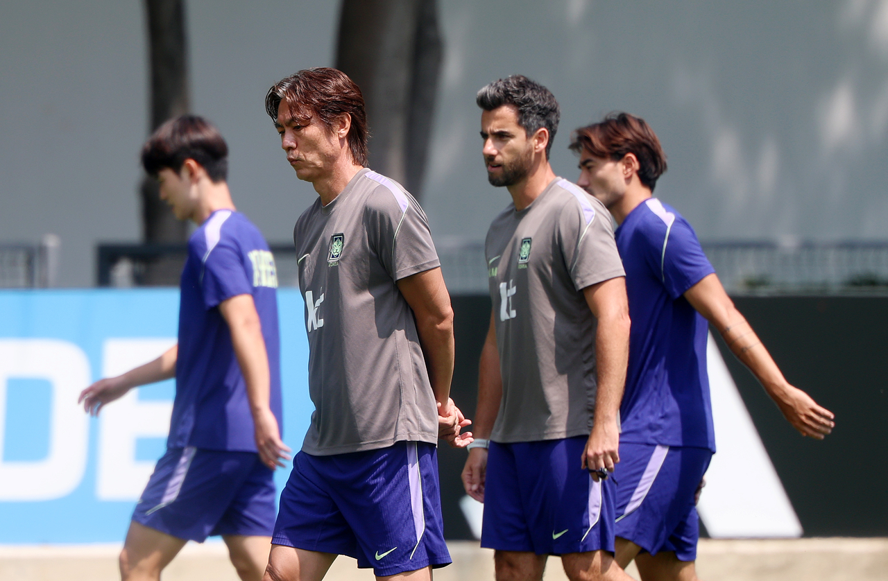 Hong Myung-bo (second from left), manager of South Korea's national soccer team, walks past players on Saturday at Guadalajara, Mexico, during a training session following the country's defeat against South Africa on Wednesday evening. (Newsis)