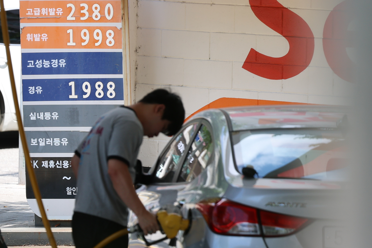 A person fills up a car with gas at a gas station in Seoul on Friday. (Yonhap)