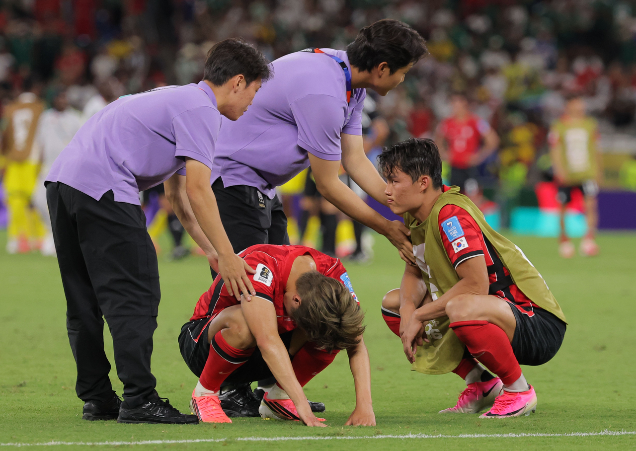 South Korean coaches comfort Paris Saint Germain attacking midfielder Lee Kang-in (left) and Besiktas forward Oh Hyun-gyu after a 0-1 defeat against South Africa, in Mexico on Wednesday. (Yonhap)