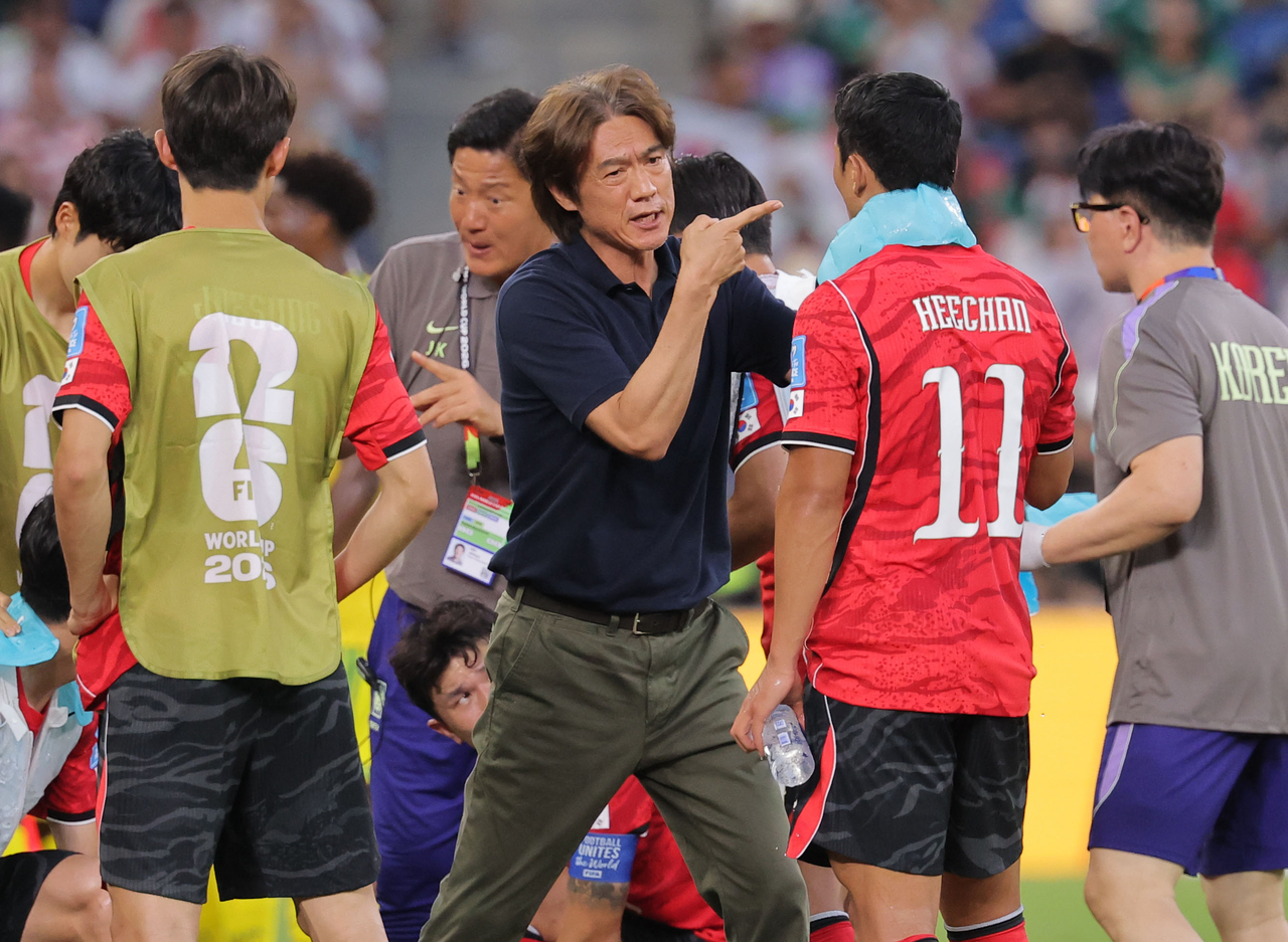 South Korean football team's head coach Hong Myung-bo (center) is seen with forward Hwang Hee-chan (second from right) during a group stage match v. South Africa in Monterrey, Mexico on Wednesday. (Yonhap)